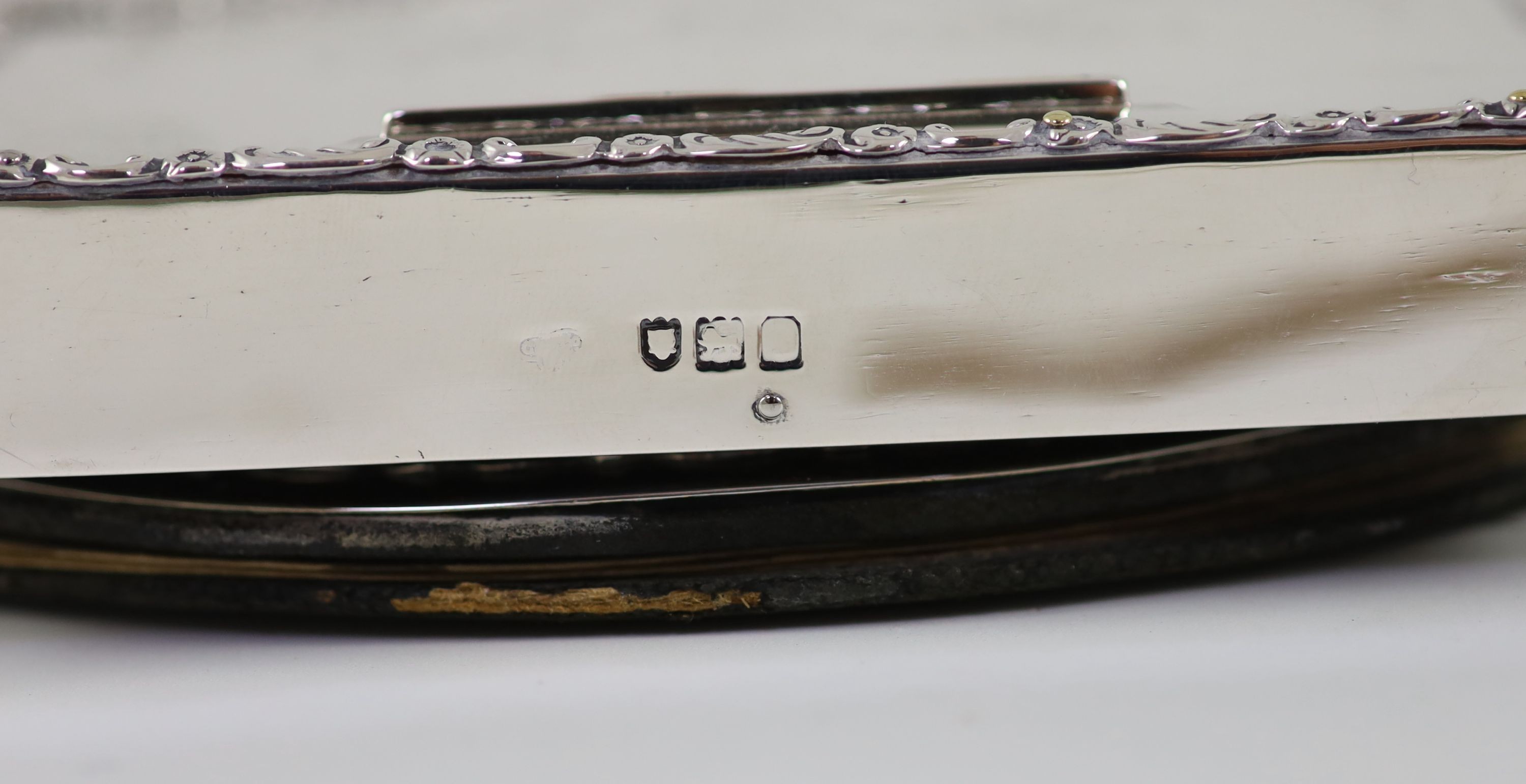 An Edwardian silver mounted leather three piece desk set, comprising a stationary box in the form of a knife box, paperweight and blotter